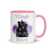 Load image into Gallery viewer, 11 oz. white ceramic coffee/tea mug with solid light pink handle, rim, and inside. Image Design: silhouette of black haunted house, cosmic purple cloud in background. Image phrase: Village witch. Right hand side view. Halloween, spooky season.
