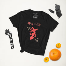 Load image into Gallery viewer, Woman&#39;s black t-shirt with image phrase: Stay Hexy (play on words for Stay Sexy), red silhouette of pretty witch form, pentacle stars on both side. Front view. Halloween, spooky season.
