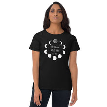 Load image into Gallery viewer, Woman modeling/wearing Woman&#39;s black t-shirt with image phrase: The moon made me do it. Bordered with Moon phases. Front view. Halloween, spooky season.
