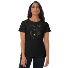 Load image into Gallery viewer, Woman modeling/wearing woman&#39;s black t-shirt with image phrase: Witchy Wanderlust. Image under phrase is a minimalist hill with a sun behind, stars in the sky, and crystal suspended above the hill. Bordered with crescent moon on either side. Front view. Halloween, spooky season.
