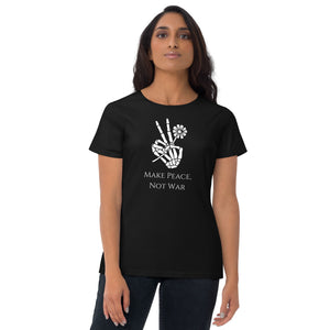 Woman modeling/wearing woman's black t-shirt with image phrase: Make Peace, Not War, underneath an image of a skeleton hand in the gesture of a peace sign, holding a daisy flower. Front view. Halloween, spooky season.