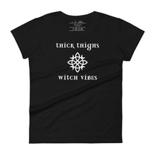 Load image into Gallery viewer, Woman&#39;s black t-shirt with image phrase: thick thighs, witch vibes. Witch&#39;s knot, with crescent moons, and star in the middle. Front view. Halloween, spooky season.
