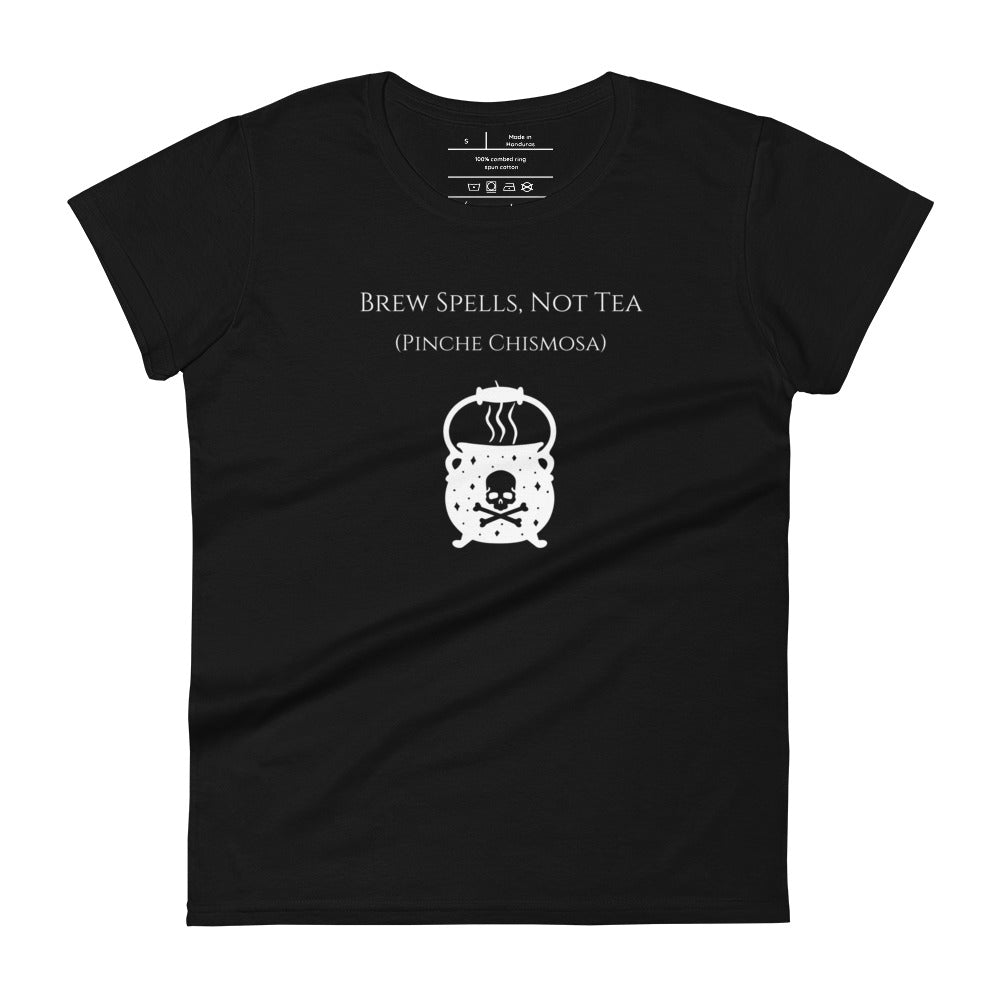 Woman's black t-shirt with image phrase: Brew spells, not tea (pinche chismosa). Underneath words is an image of a cauldron decorated with stars and skull with crossbones. Front view. Halloween, spooky season.