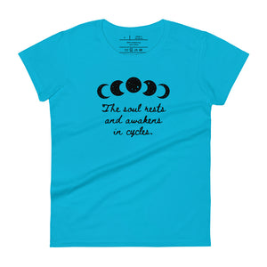 women's caribbean blue t-shirt, with image of black celestial moon phases, with star cut outs, and image phrase "The soul rests and awakens in cycles." Front view.