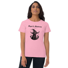 Load image into Gallery viewer, Woman modeling/wearing woman&#39;s light pink t-shirt with image phrase: Magical &amp; Mischievous, with image of black cat wearing a black hat underneath. Front view. Halloween, spooky season.
