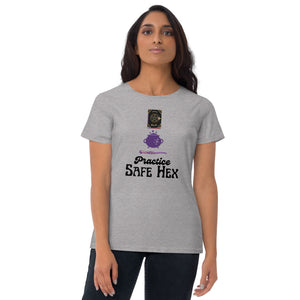 Woman modeling/wearing woman's light grey t-shirt with image phrase: Practice safe Hex (play on words for 'Practice safe sex.' Above phrase is a spell book, a cauldron, a wand. Front view. Halloween, spooky season.