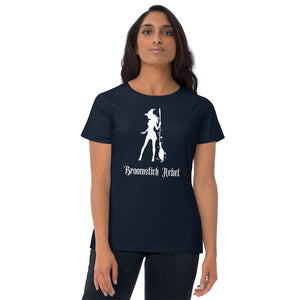 Woman modeling/wearing woman's navy blue  t-shirt with image phrase: Broomstick rebel, with image of witch silhouette holding a broom, surrounded by star. Front view. Halloween, spooky season.