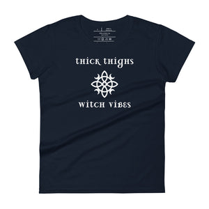 Woman's navy blue t-shirt with image phrase: thick thighs, witch vibes. Witch's knot, with crescent moons, and star in the middle. Front view. Halloween, spooky season.