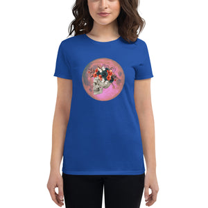 woman modeling/wearing women's royal blue t-shirt, with image design: side profile of a skull wearing a crown/hat of black roses, red poppies, thorny vines, and white butterflies, with a pink-red moon behind it. Front View.