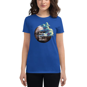 woman modeling/wearing women's royal blue t-shirt with image design of a dark moon, with a colorful dawn cloud in front, with image phrase: "Darkness precedes the Dawn." Front View.