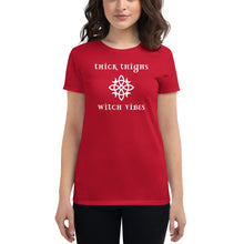 Load image into Gallery viewer, Woman modeling/wearing woman&#39;s red t-shirt with image phrase: thick thighs, witch vibes. Witch&#39;s knot, with crescent moons, and star in the middle. Front view. Halloween, spooky season.
