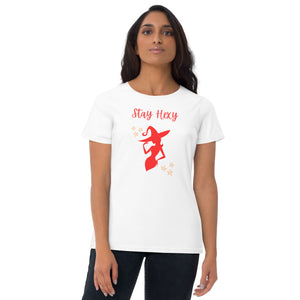 Woman modeling/wearing woman's white t-shirt with image phrase: Stay Hexy (play on words for Stay Sexy), red silhouette of pretty witch form, pentacle stars on both side. Front view. Halloween, spooky season.