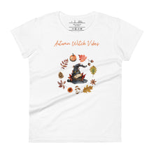 Load image into Gallery viewer, Woman&#39;s white t-shirt with image phrase in light orange font: Autumn Witch Vibes, with image of picturebook witch hat adorned with brown vines, autumn leaves, red-orange berries. A circle of leaves, acorns, pinecone, daisy flower, and mushroom, encircled the hat. Front view. Halloween, spooky season.
