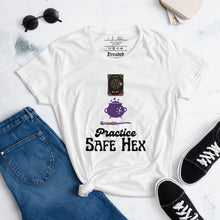 Load image into Gallery viewer, Woman&#39;s white t-shirt with image phrase: Practice safe Hex (play on words for &#39;Practice safe sex.&#39; Above phrase is a spell book, a cauldron, a wand. Front view. Halloween, spooky season.
